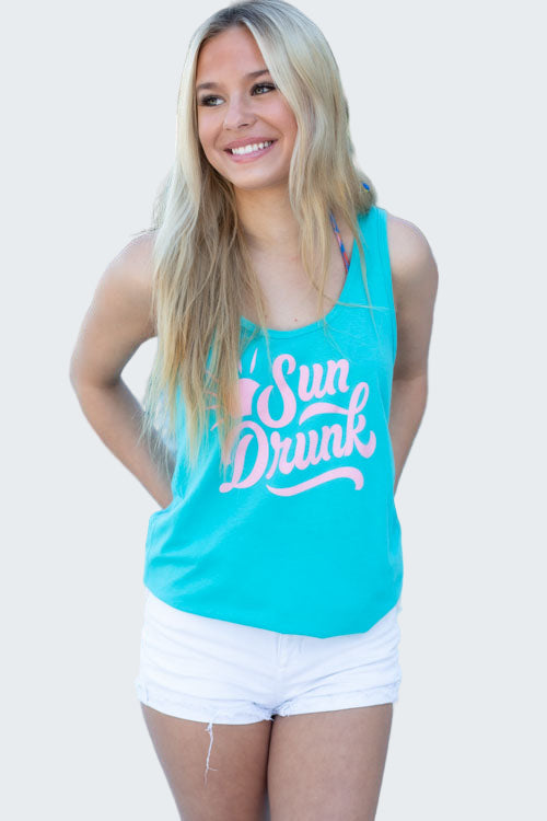Woman wearing a turquoise tank top with 'Sun Drunk' text by a pool.