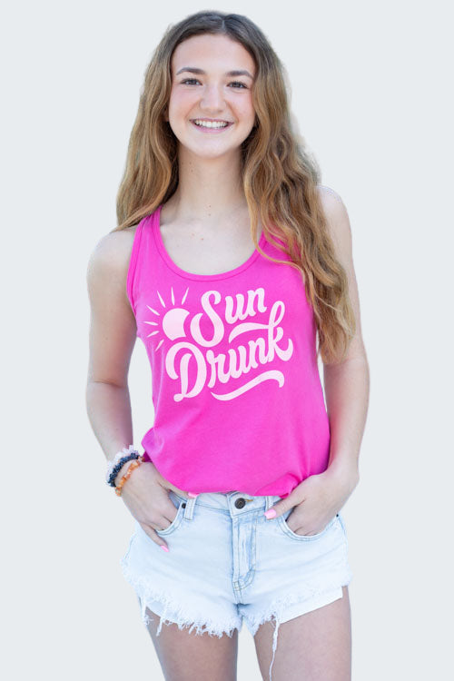 Woman wearing a pink 'Sun Drunk' tank top by a pool
