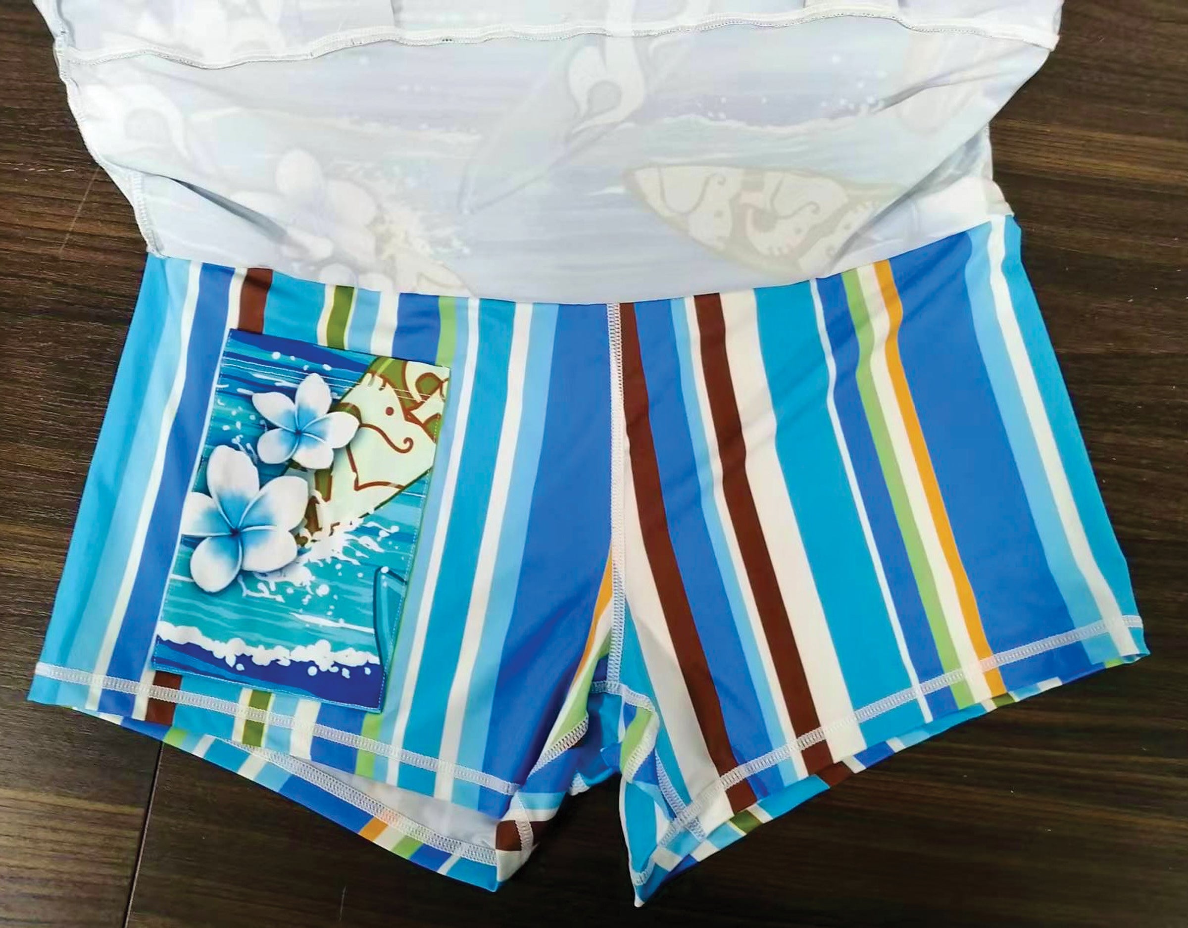 Colorful striped shorts with floral design on a wooden surface