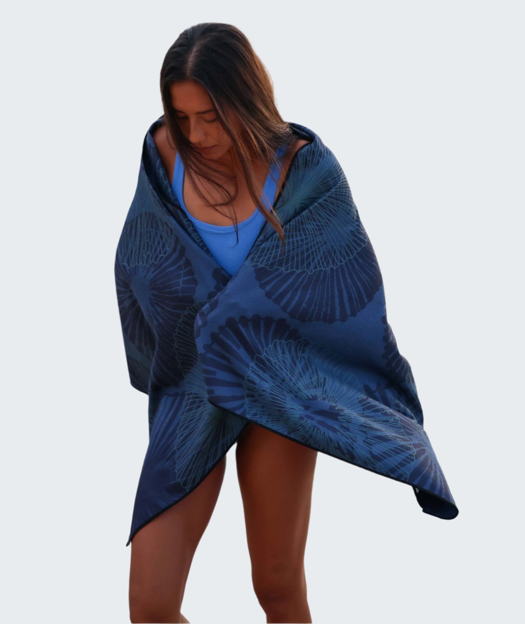 Woman wrapped in a blue patterned towel on a beach