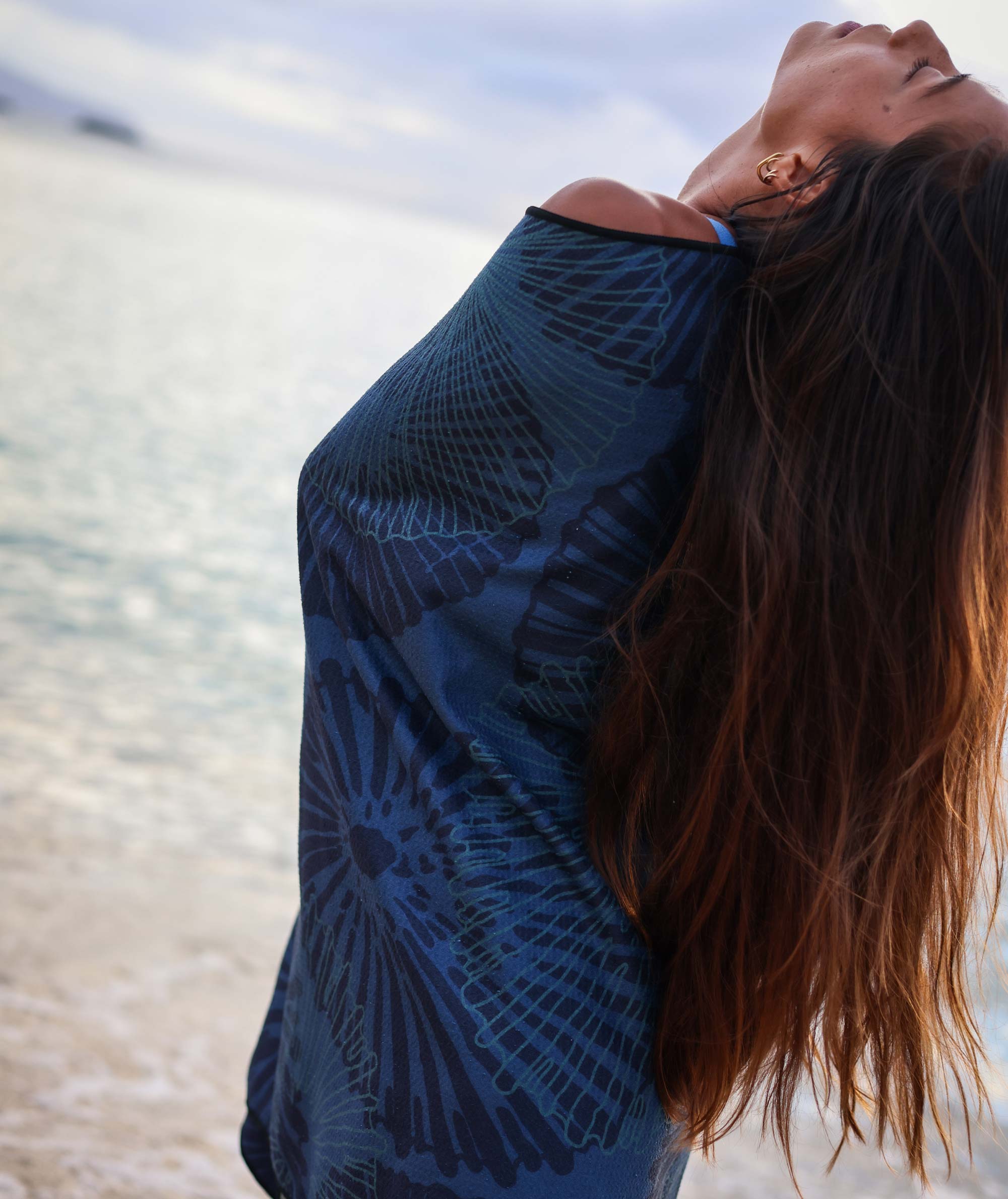 Woman wearing a blue patterned top with a blurred natural background