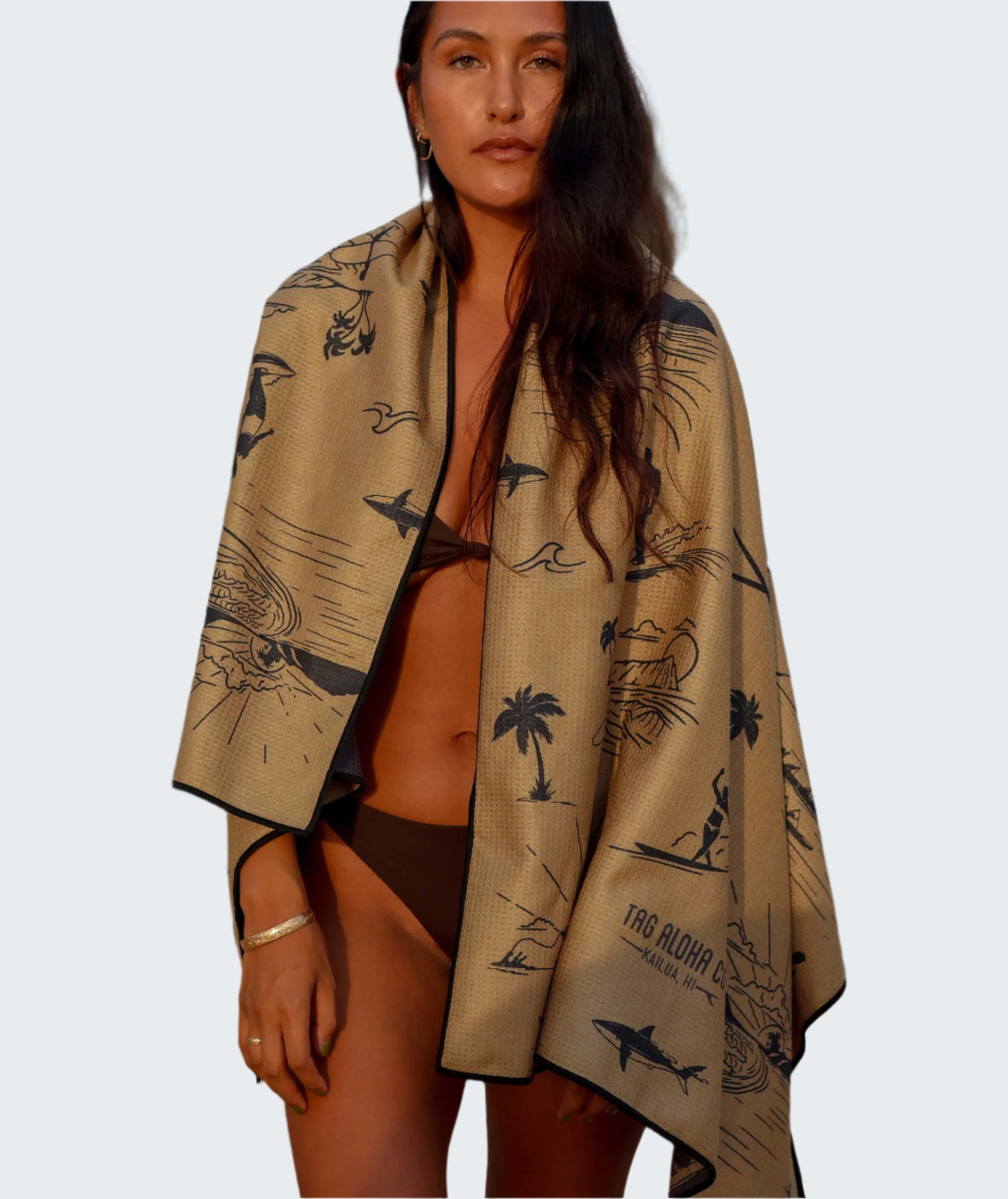 Woman wrapped in a patterned towel on a beach