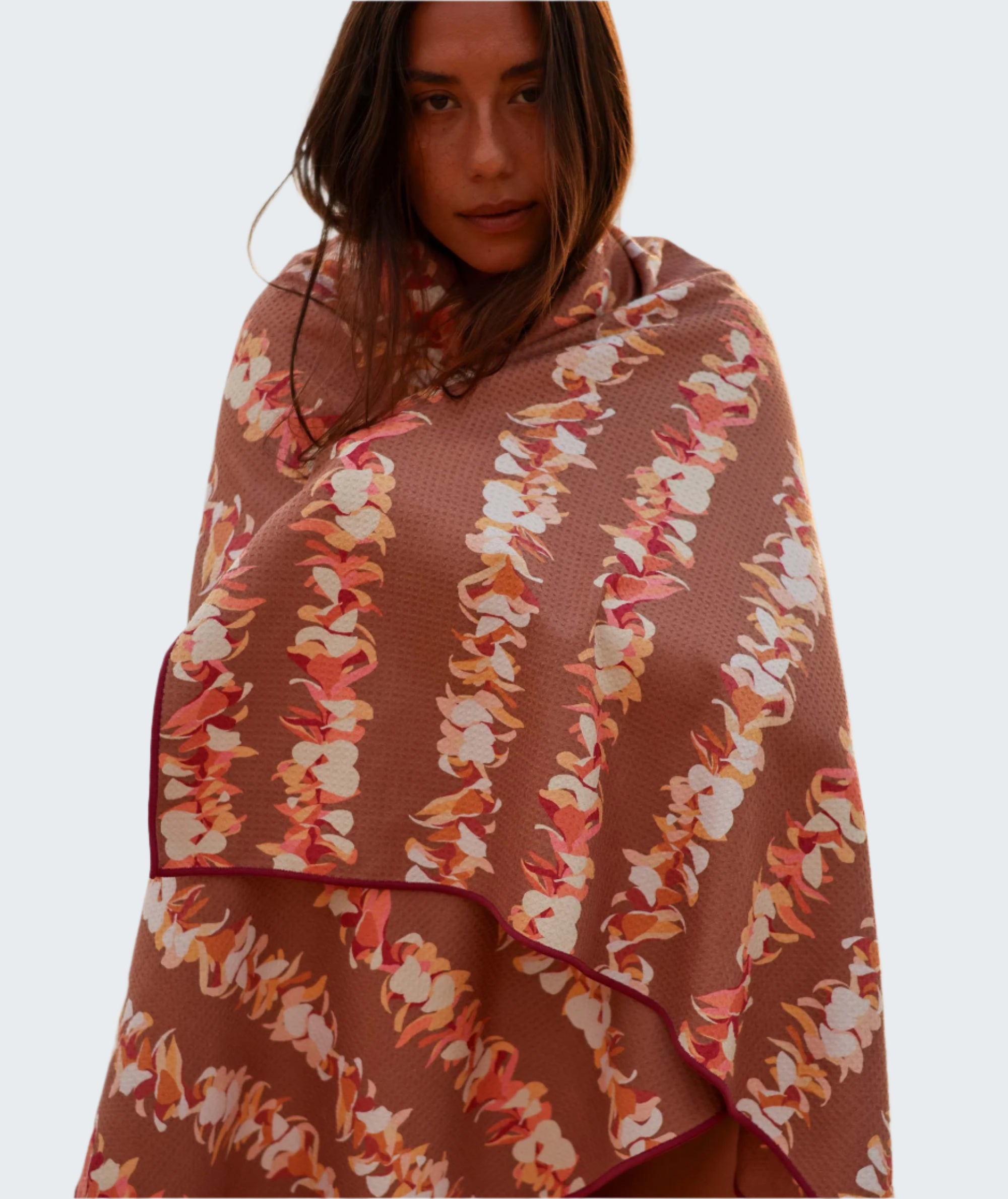 Woman wrapped in a floral-patterned towel by the water