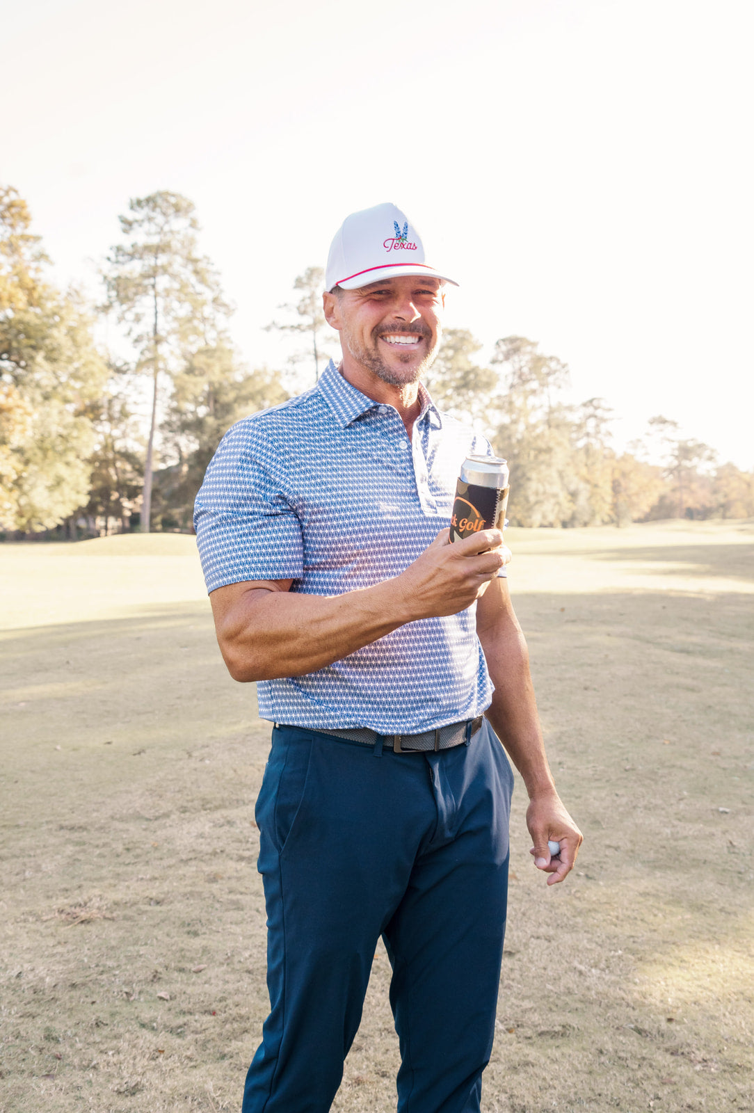 Man holding a glass of red wine on a golf course