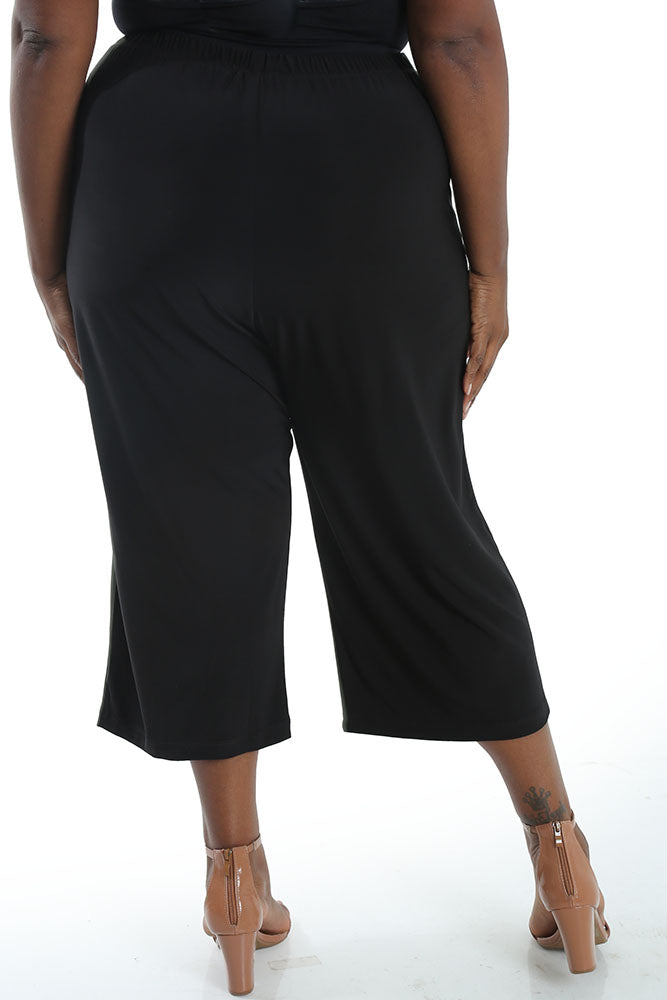 Person wearing black wide-leg pants on a white background