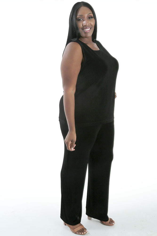 Woman wearing a black sleeveless top and pants on a white background