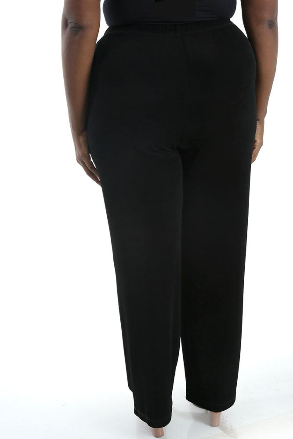 Black pants worn by a person on a white background