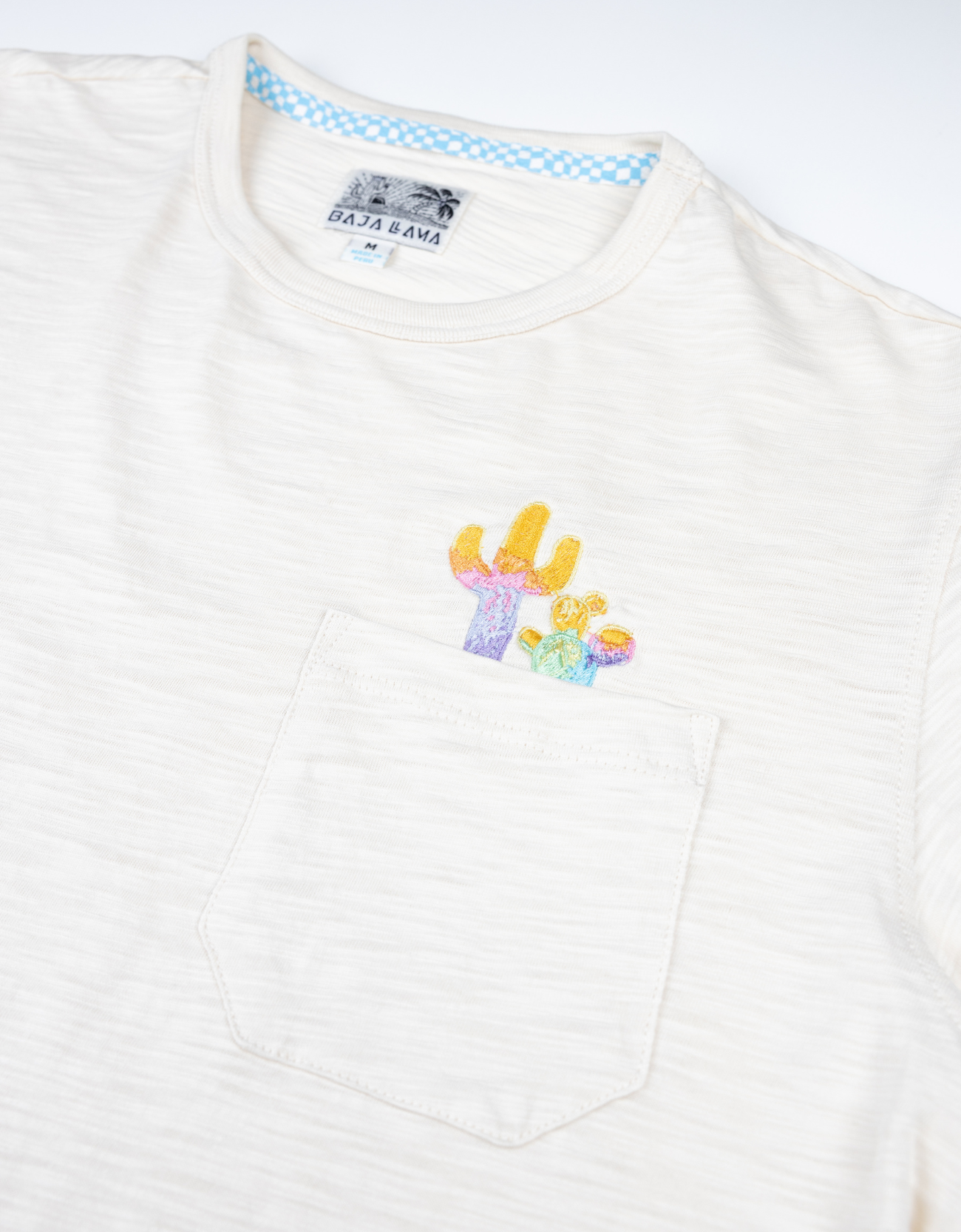 White t-shirt with colorful hand design and 'Dada Gama' branding on a white background