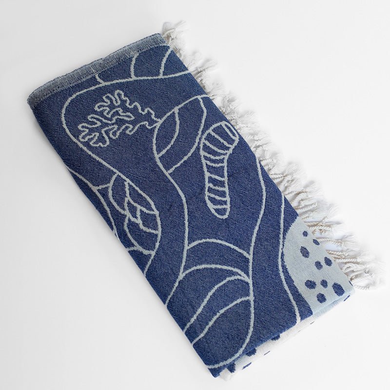 Blue towel with white wave pattern on a light gray background