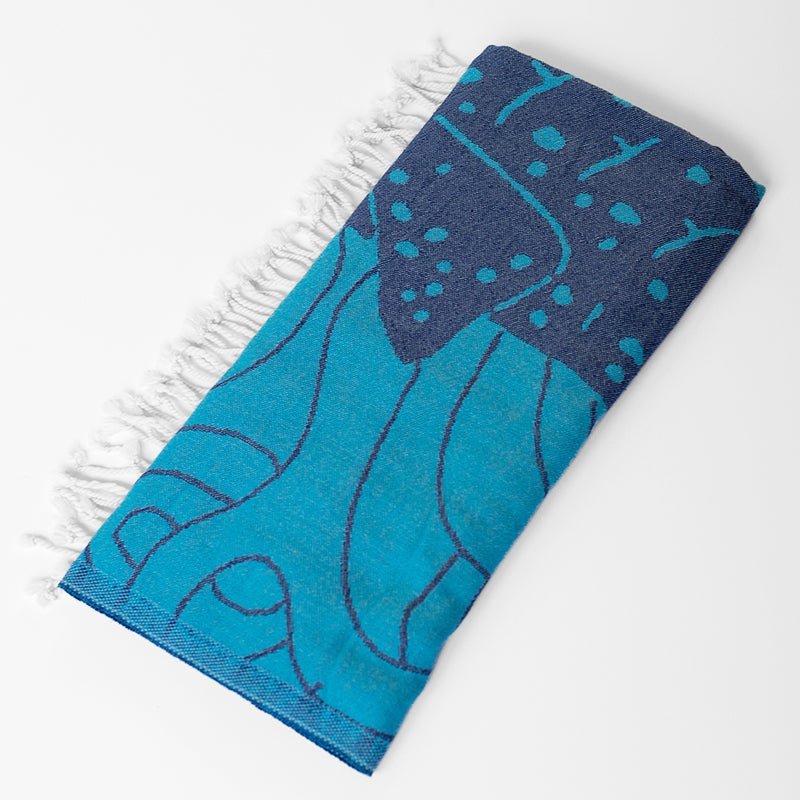 Blue towel with white fringe on a white background