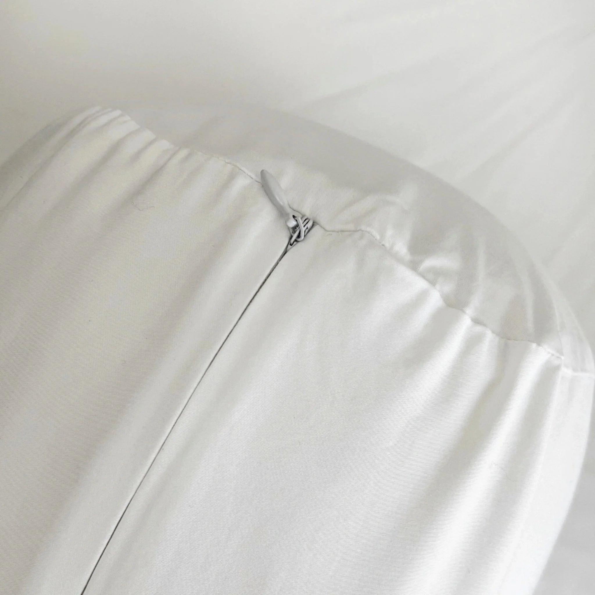 Close-up of a white leather jacket with a zipper detail on a light gray background