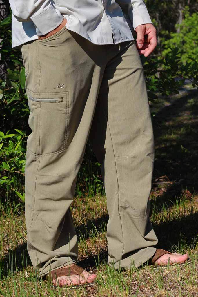 Person wearing beige cargo pants standing in a natural setting with greenery.