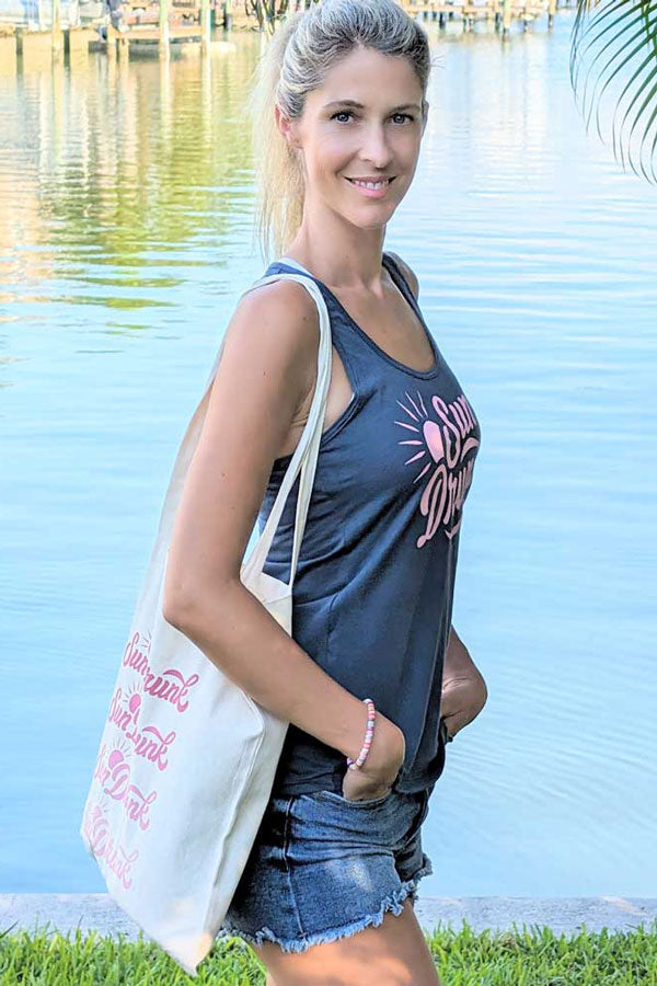 Woman holding a tote bag by a body of water