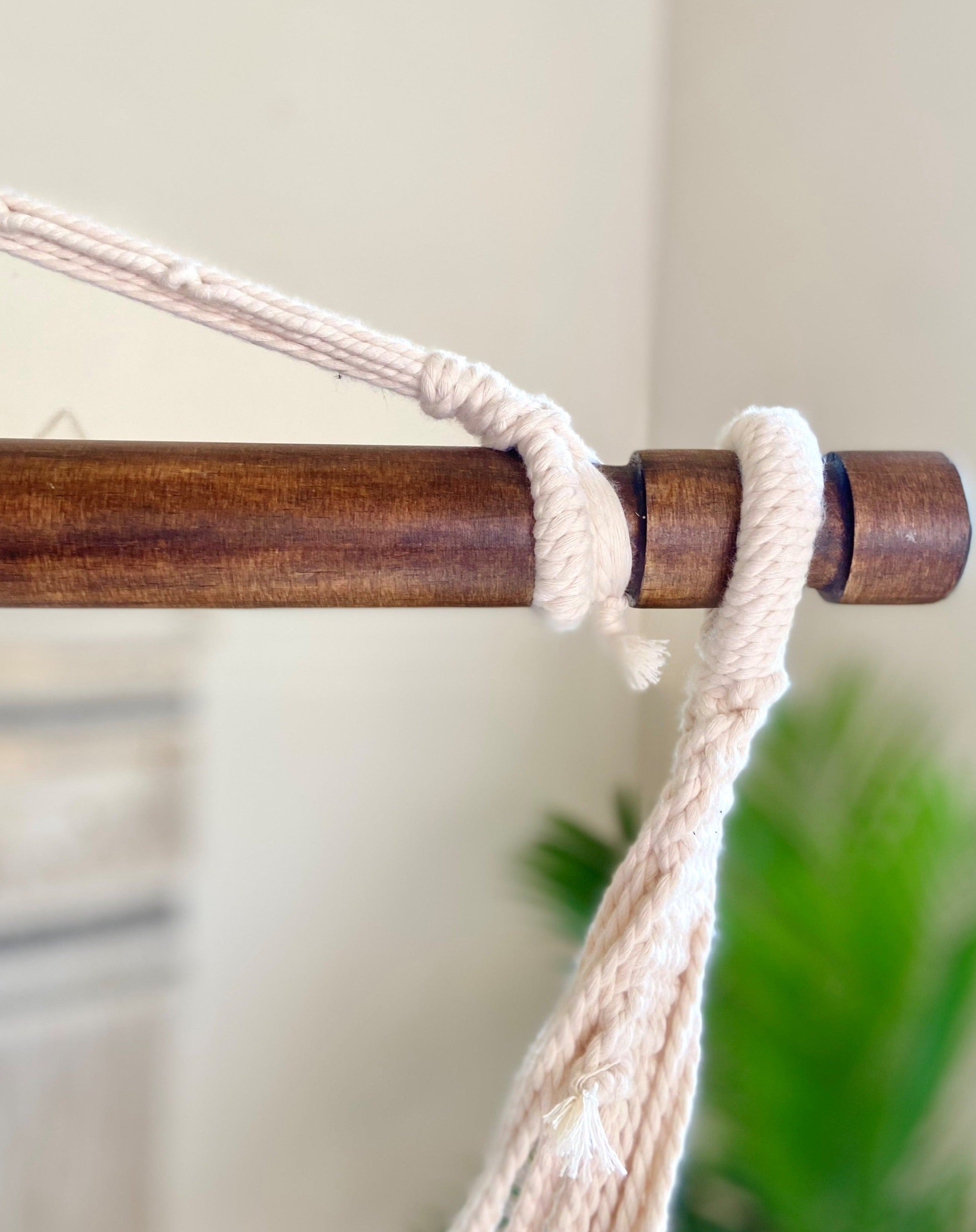 Close-up of a wooden rod with macrame hanging, blurred background