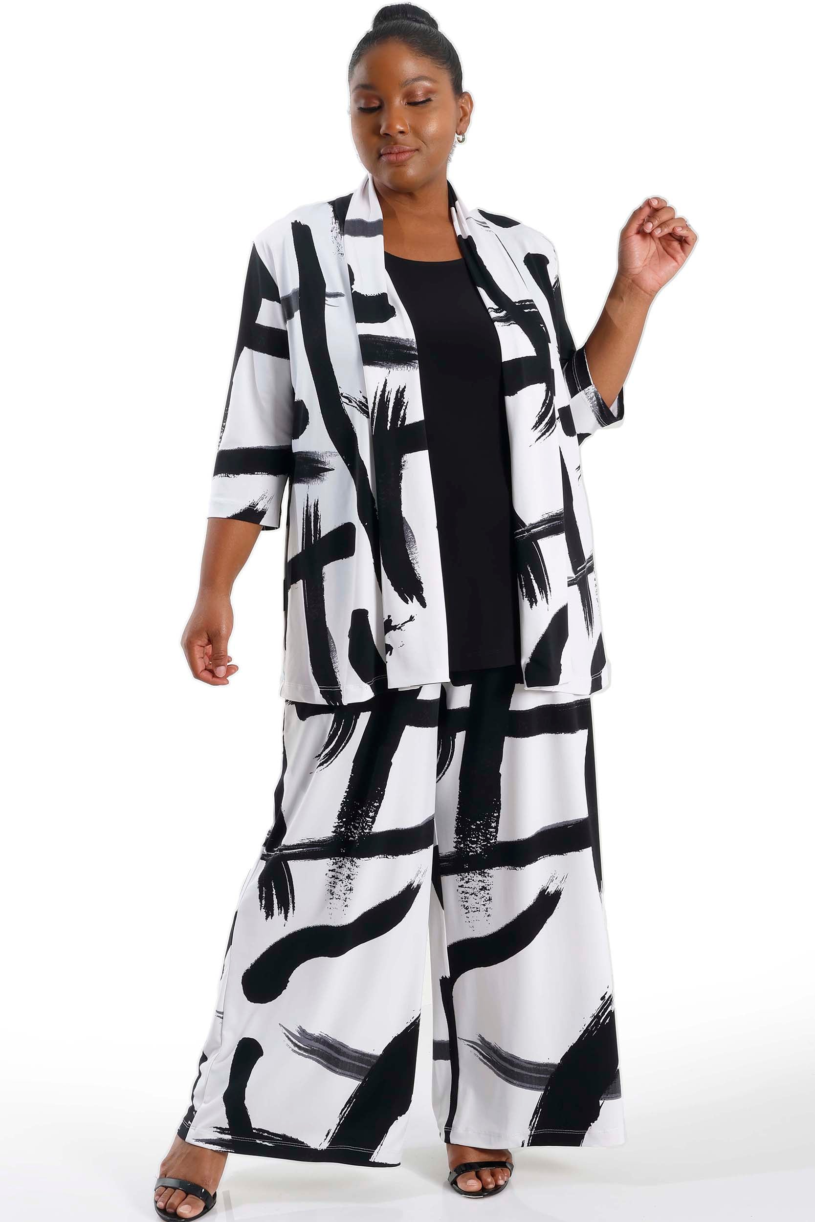 Woman wearing a black and white abstract patterned outfit on a white background