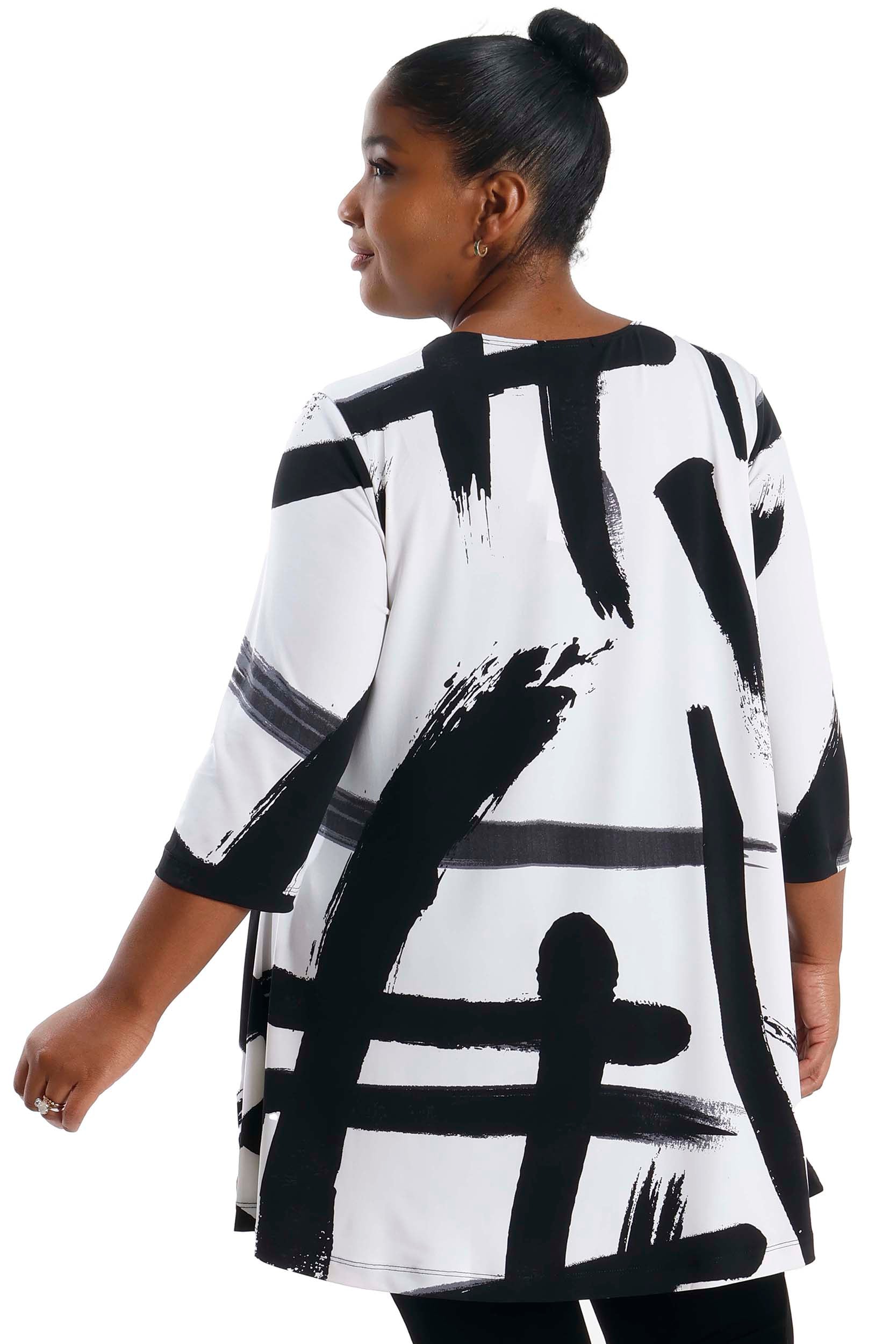 Person wearing a black and white abstract patterned dress on a white background