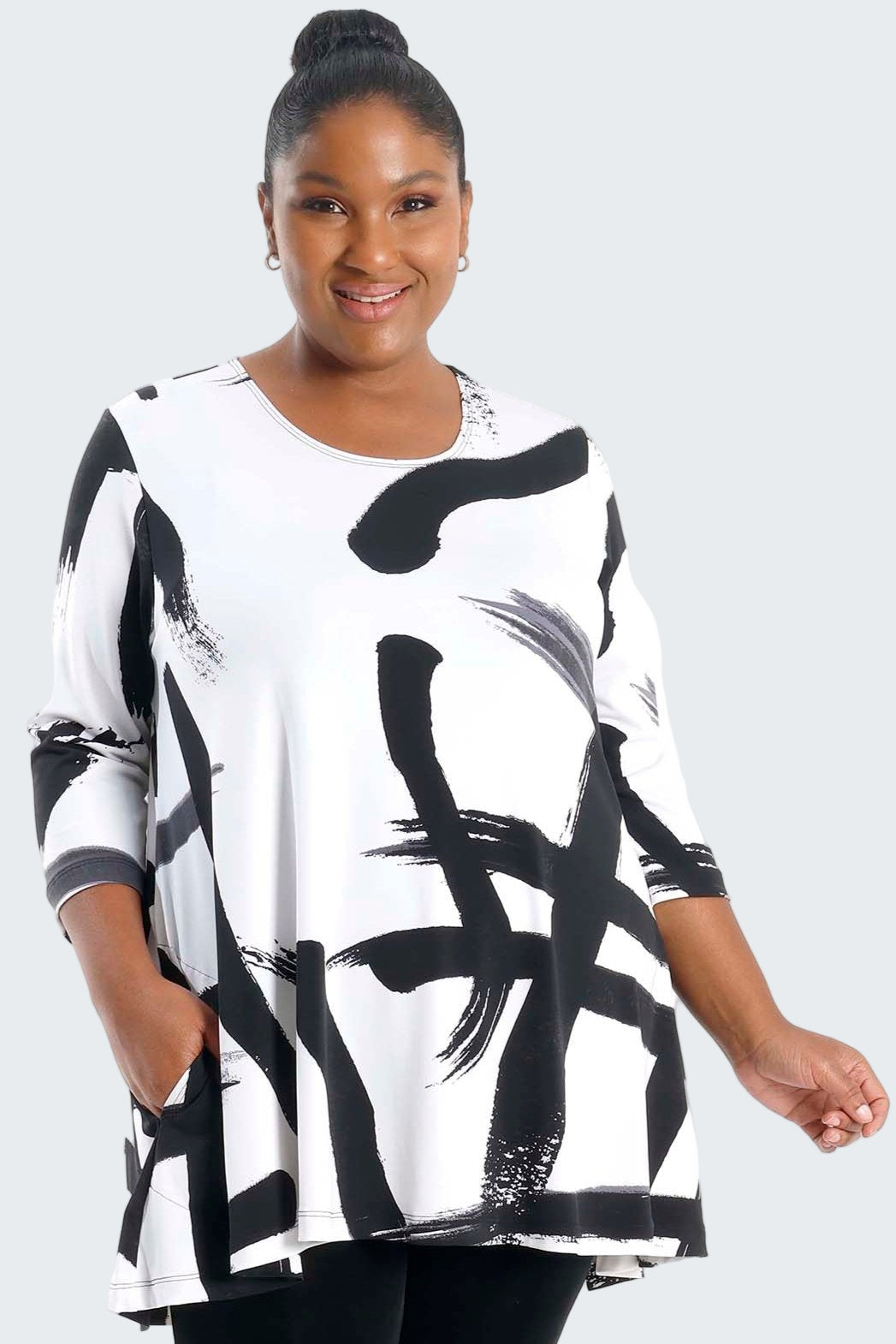 Woman wearing a black and white abstract patterned dress on a white background