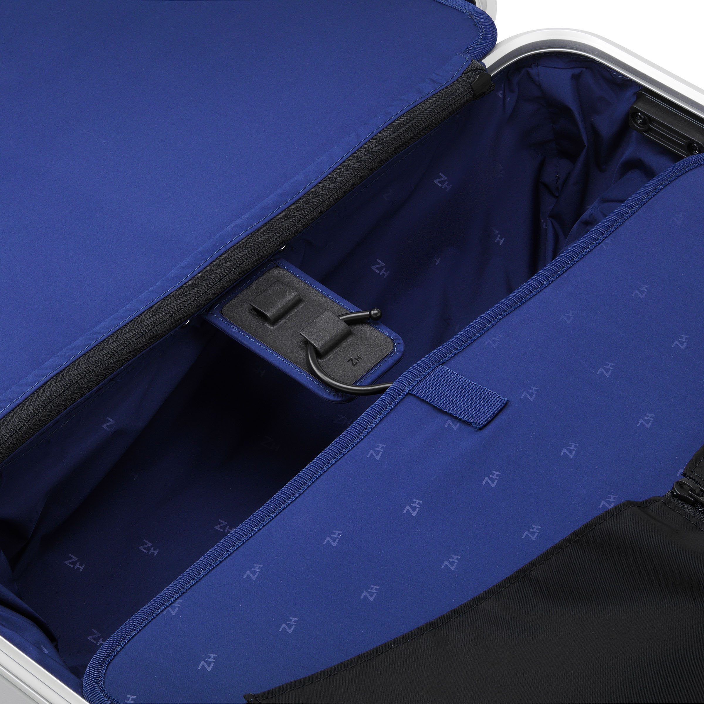 Open suitcase with blue interior lining and visible brand logo.